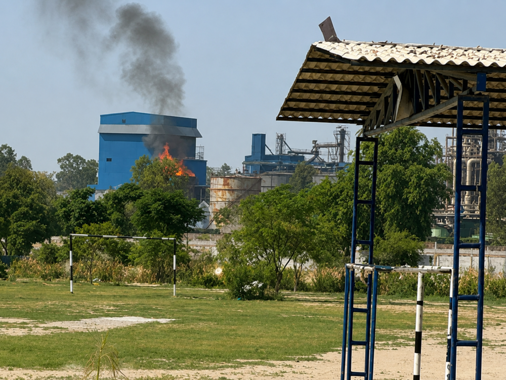 Industrial factory area with flames and smoke rising from a plant, representing a fire and explosion incident.