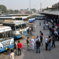 Passengers and transport employees gathered at a Punjab bus terminal with multiple buses parked during disruptions caused by the PRTC and PUNBUS workers' strike.