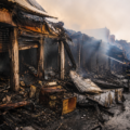 Firefighters inspect and contain the aftermath of a major blaze at a commercial market in Amritsar, where multiple shops were destroyed and significant property damage occurred.