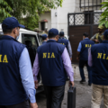 National Investigation Agency officers and security personnel conducting a coordinated search operation outside a residential property during an anti-terror investigation in Punjab and Haryana.