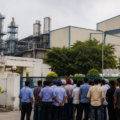 Industrial workers standing outside a factory facility in Punjab amid concerns over employment and operational uncertainty.