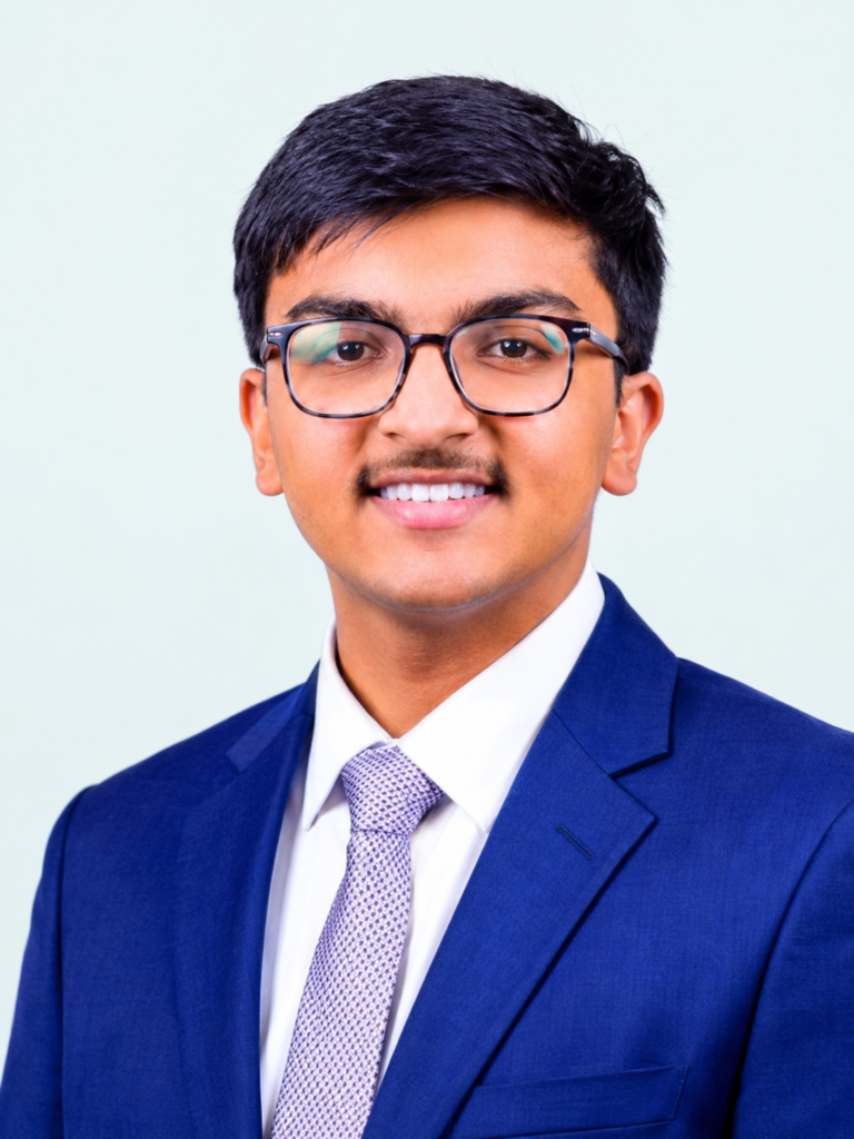 Professional portrait of a young man wearing a formal suit and glasses, representing academic achievement and success.
