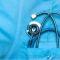 Close-up of a medical professional's uniform with a stethoscope placed in the front pocket, symbolizing healthcare services and public health initiatives.