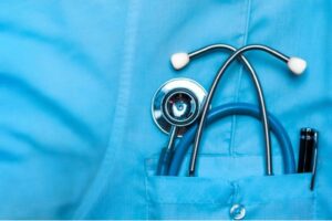 Close-up of a medical professional's uniform with a stethoscope placed in the front pocket, symbolizing healthcare services and public health initiatives.