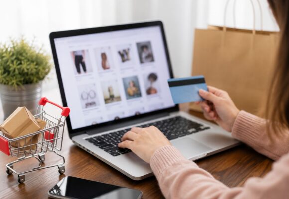 Customer shopping online using a laptop with digital shopping icons
