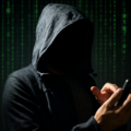 Hooded person using a mobile phone, symbolizing a cyber extortion threat after a Karnal trader allegedly received a ₹1 crore ransom demand via WhatsApp.