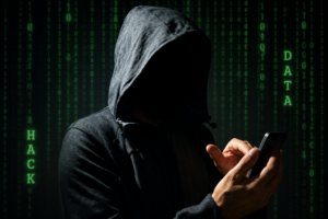 Hooded person using a mobile phone, symbolizing a cyber extortion threat after a Karnal trader allegedly received a ₹1 crore ransom demand via WhatsApp.