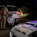 Police arresting a suspected drug smuggler during a nighttime anti-narcotics operation in Kaithal, Haryana.