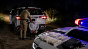 Police arresting a suspected drug smuggler during a nighttime anti-narcotics operation in Kaithal, Haryana.